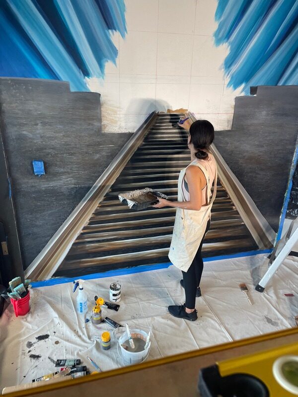 Brit Albin painting the train and rails on site